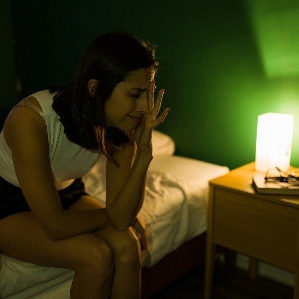 a woman struggles to sleep after discovering bed bugs in her bed